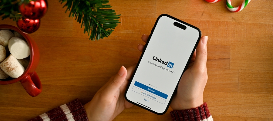Phone with LinkedIn on the screen, surrounded by Christmas decorations
