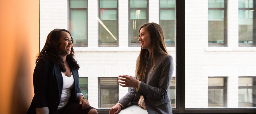 Two colleagues sat together smiling