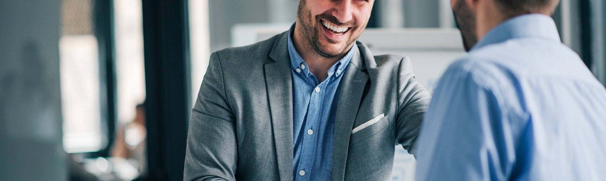 Two men in suits laughing