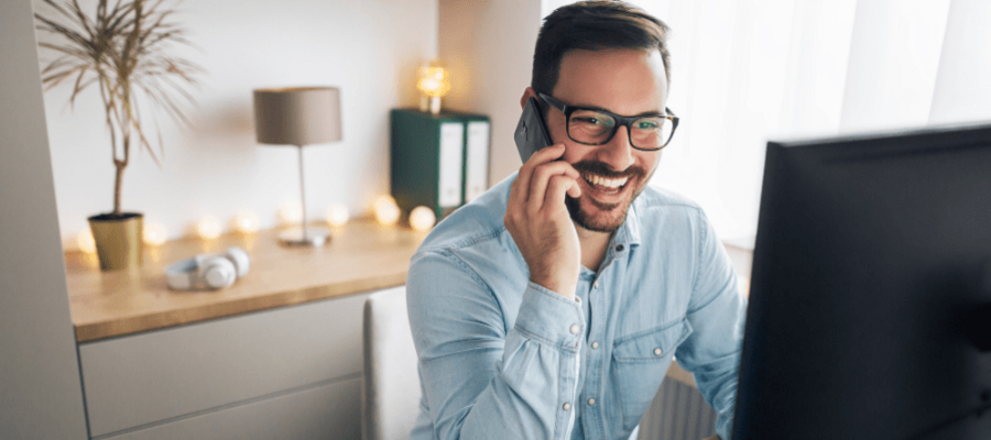 A man with brown hair on a work call smiling