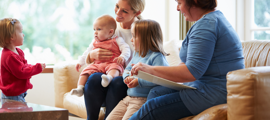 A woman sat down with her three children while being visited by a family social worker