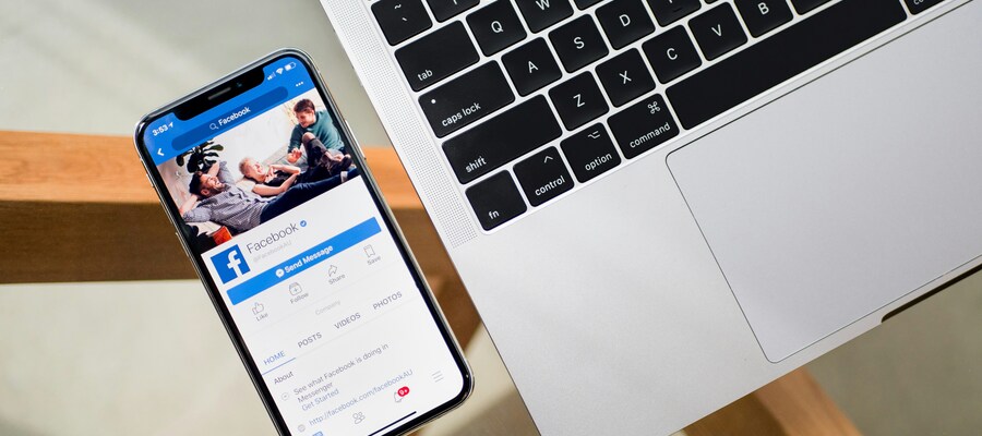 Phone and laptop displaying Facebook